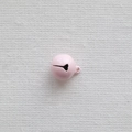 Detailed view of a 14mm pink metal bell with hanging loop on a natural linen background - Light Pink
