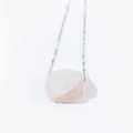Macro shot of natural irregular raw pink crystal pendant on a silver-tone chain necklace - Rose Quartz