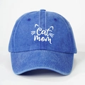 Macro detail of 'Cat mom' embroidery and feline line art on washed denim baseball cap - Royal Blue