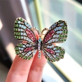 Golden butterfly brooch with vibrant green and pink crystals held in hand for detail - Multi-Color Butterfly-Green Blue Pink (XZ0296-4)