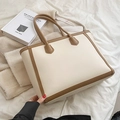 Grande borsa tote in pelle PU beige e marrone su sfondo bianco testurizzato con libro - Bianco
