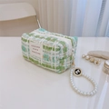 Detail of tweed makeup bag with pearl handle and golden zipper on white surface - Tweed Green