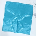 Flat lay of soft blue satin silk square scarf showing fabric texture and edge details - Sky Blue