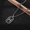 Macro detail of silver necklace featuring a black enamel rectangle pendant with H logo - XL10 / 'H' Pendant / Silver Black