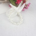 Elegant white faux pearl bracelet for girls displayed on a ceramic hand model - 5MM+10MM Mixed Size Cream White Pearl Bracelet