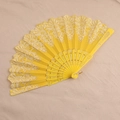 Spanish style yellow lace folding fan with floral patterns and gold accents on plastic frame - Yellow