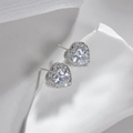 Macro shot of heart-shaped silver earrings with sparkling cubic zirconia on a white tray - Heart Shape White Zirconia Studs