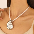 Close-up of silver conch shell pendant on a white rope necklace for beach style - Silver Conch Necklace