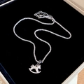 Macro shot of silver rocking horse pendant with hammered texture and fine chain - Silver