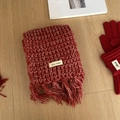 Dettaglio del set sciarpa e guanti in maglia rossa su pavimento in legno chiaro - Set sciarpa e guanti rossi