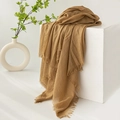 Elegant brown cotton linen scarf with tassel edges on minimalist white pedestal - Khaki