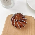 Détail d'une pince à cheveux nid d'oiseau marron avec strass sur un plateau - Plein Strass (Marron)