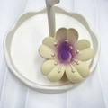 Pale yellow frangipani flower hair claw clip with purple center gradient on white tray - Purple Center (Rubber Paint Lucky Flower)