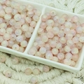 Makro-Detail von 6mm rosa Glasperlen mit Crushed-Effekt in einer Keramikschale - Jade-Textur Gelb-Rosa (6mm)
