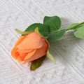 Single orange artificial silk rose with green leaves on white knit background - Rose Bud (Orange)