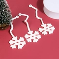 Macro detail of white snowflake ornaments with wavy strings on festive red background - White Snowflake