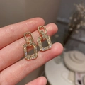 Macro shot of gold geometric link earrings with sparkling crystal pavé details - Gold