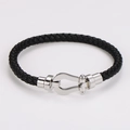 Dettaglio di un bracciale in pelle intrecciata nera con chiusura a ferro di cavallo in argento - Colore Acciaio (Corda Nera)