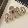 Detalle de pinza para el pelo ondulada de acetato café con dientes de metal dorado elegante - Color Té con Leche