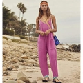 Women's purple bohemian jumpsuit with zipper pockets shown in a beach setting - Purple