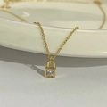 Halskette aus 925er Silber 18K vergoldet mit Zirkonia-Schlossanhänger auf weißer Keramik - 925er Silber / 18K Gold