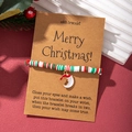 Close-up of polymer clay Christmas bracelet with Santa pendant on wish card packaging - Moon Santa