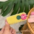 Detail of yellow plush hair clip with green and pink buttons and a cute bow tie - Yellow