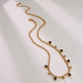 Detail of gold beaded chain necklace with deep green round gemstones and adjustable clasp - Gold Green Zirconia