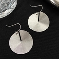 Detail of silver textured circular earrings with concentric rings on dark fabric - Concentric Circular Texture Disc Silver (N-621)
