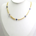 Close-up of gold chain necklace featuring five blue and white evil eye charms on a bust - Sapphire Blue