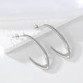 Detail of silver V-shaped stainless steel earrings on white textured stone and silk - 1188 Steel Color U-Shape