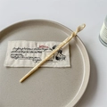 Detail of mermaid acetate hair stick with light yellow marble texture on ceramic plate - Cream