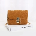 Brown teddy fleece crossbody bag with a gold lock and chain strap on a white stand - Tan
