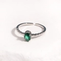 Vue macro d'une bague argentée ajustable avec une pierre ovale verte griffée - Pierre Précieuse Verte Base Argentée
