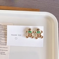 Détail de boucles d'oreilles bonhomme de pain d'épices avec nœuds verts sur carte - Bonhomme de pain d'épice - Clou