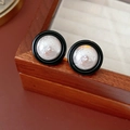 Gros plan détaillé de boucles d'oreilles rétro avec émail noir et centre nacré blanc - Style rond martelé / Argenté