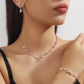Dettaglio del set di gioielli in oro rosa con strass scintillanti su modella - Collana Orecchini Bracciale (80808636) / Oro rosa