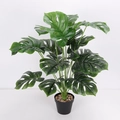 Artificial Monstera Deliciosa plant in a black plastic pot with decorative pebbles - 18-Head Large Monstera Leaf Green Edge (Without Pot)