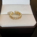 Primer plano de anillo de cadena dorada con circonitas brillantes en estuche de joyas - Anillo N.° 38-cadena De Oro.