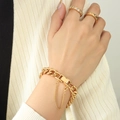 Pulsera de cadena gruesa dorada con borlas y anillos a juego en la mano del modelo - Pulsera-18cm / Dorado