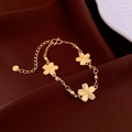 Detail of 18k gold plated bracelet with cherry blossom pendants on dark brown fabric - Gold - Three Sakura Peach Blossoms
