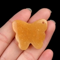 Hand-carved orange agate butterfly pendant with natural stone textures and top hole - Topaz