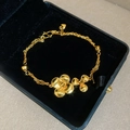 Detailed macro view of 24K gold-plated double-layer chain bracelet with floral charms - Gold-Double Flower
