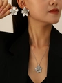 Elegant silver flower earrings and necklace set styled on a model in a black blazer - Silver Flower Earrings + Necklace Set