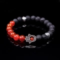 Detailed view of black lava rock beads and Hamsa Hand charm on handmade bracelet - Red Agate