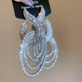 Dettaglio di orecchini pendenti geometrici argentati con cristalli brillanti multistrato - Argento