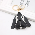 Close-up of black and white leather beagle keychain with contrast stitching and gold clasp - Black