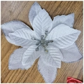 Close-up of silver glitter artificial poinsettia flower on a warm wooden background - Silver