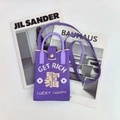 Détail du mini sac bandoulière tricoté violet avec texte jaune et fermoir argenté - S'Enrichir (Violet)