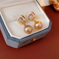 Detalle de pendientes dorados cuadrados vintage con perla en un joyero de terciopelo - Pin de Plata-Oro-Champaña
